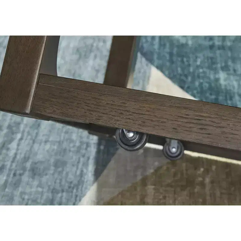 Signature Design by Ashley Breckington Tavolino da caffè - Finitura in legno marrone scuro con rotelle, ripiano inferiore portaoggetti