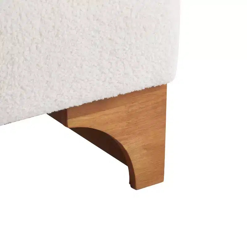 Poltrona Homy Casa con schienale arrotolato e base in legno massello, rivestimento in tessuto bouclé