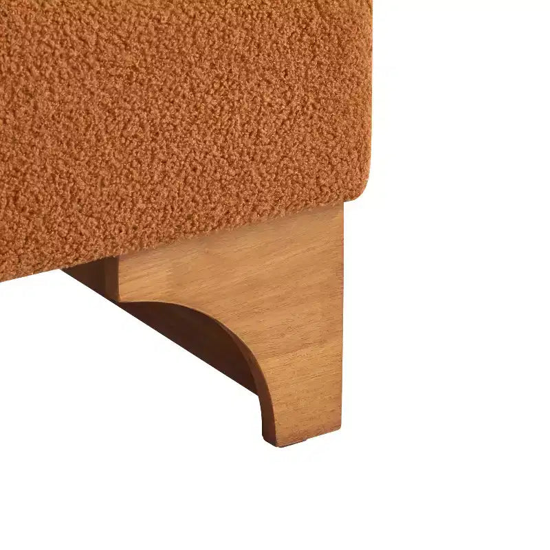 Poltrona Homy Casa con schienale arrotolato e base in legno massello, rivestimento in tessuto bouclé
