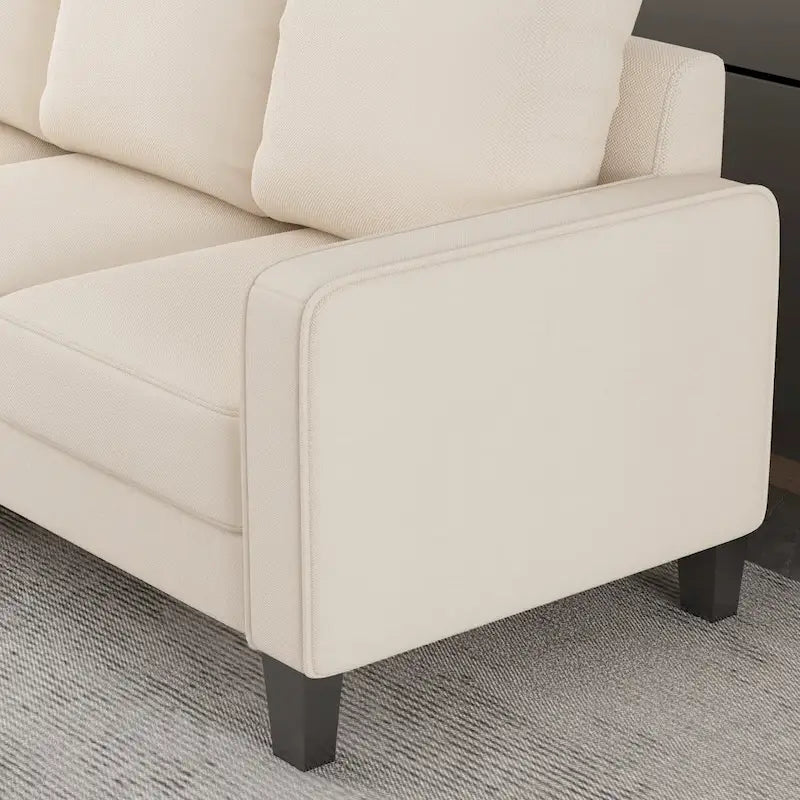 Divano in tessuto beige con bracciolo squadrato e schienale trapuntato