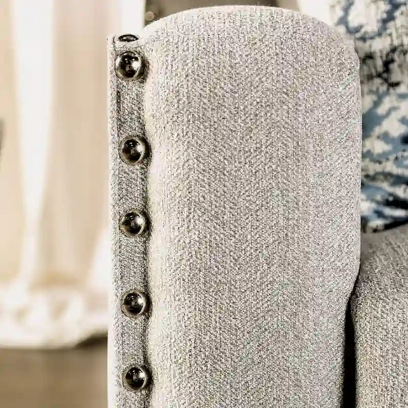 Divano Kenwood di Furniture of America, rivestito in tessuto grigio chiaro, con finiture borchiate e braccioli inclinati, stile transizionale