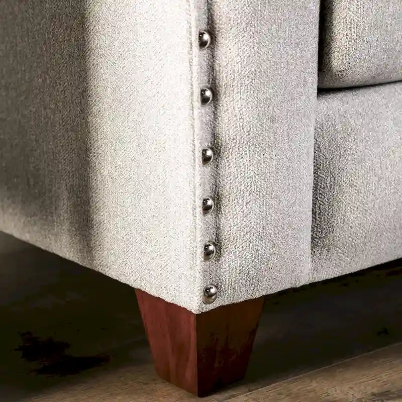 Divano Kenwood di Furniture of America, rivestito in tessuto grigio chiaro, con finiture borchiate e braccioli inclinati, stile transizionale